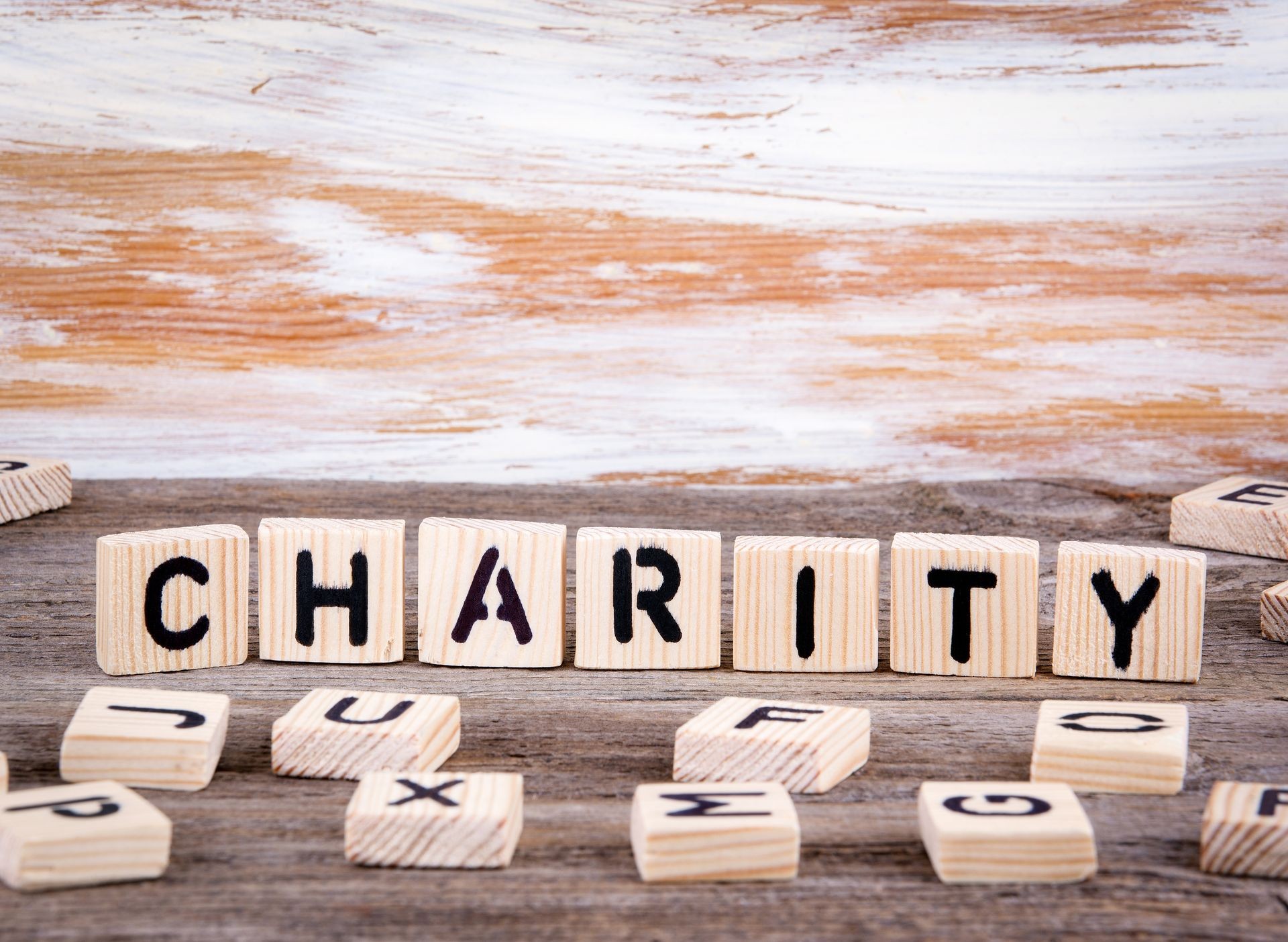 Charity from wooden letters on wooden background