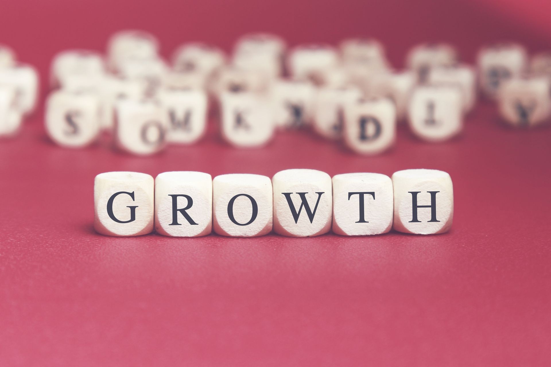 Growth word written on wood cube with red background